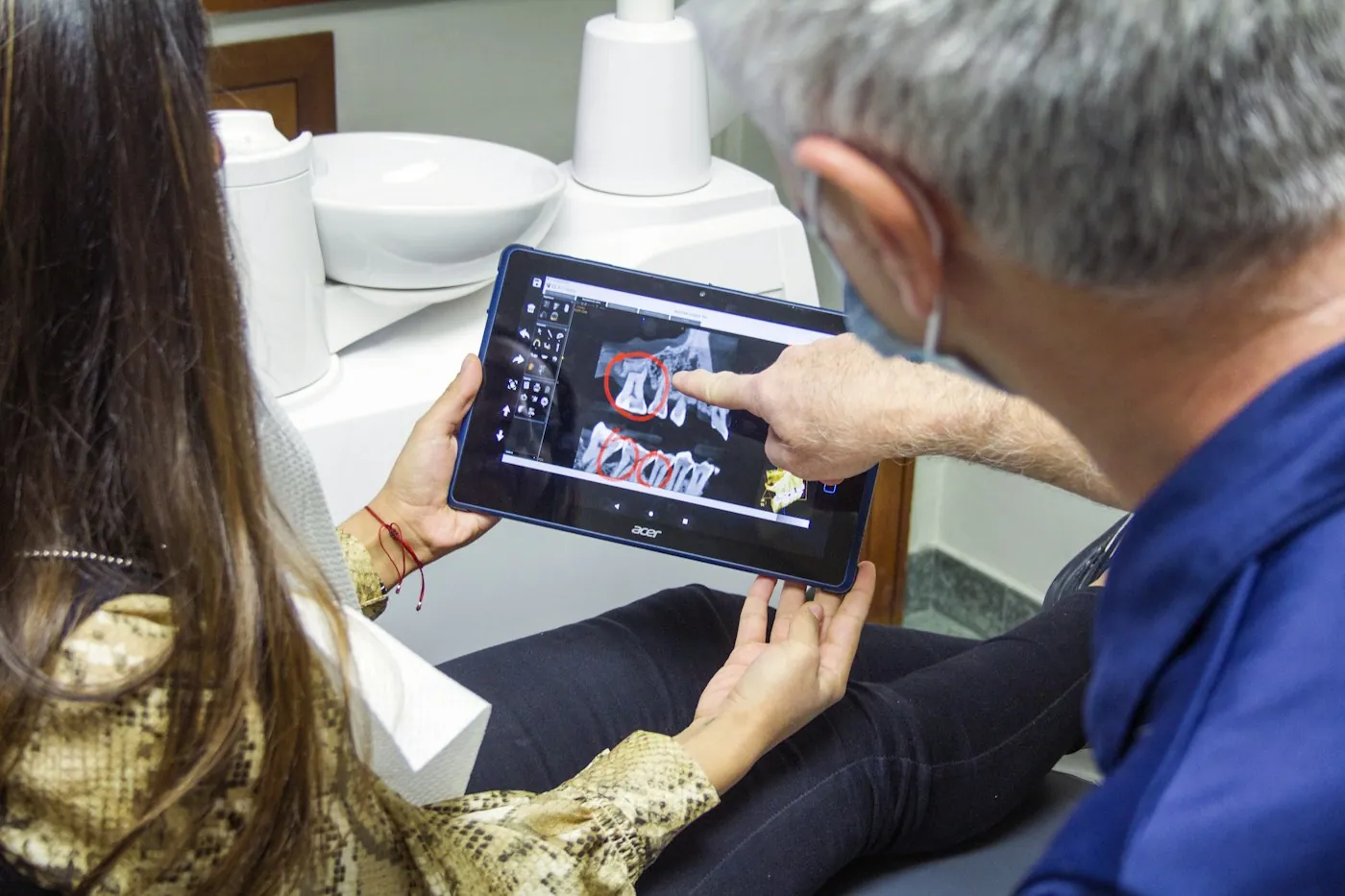 Dentist showing a patient her treatment on a tablet